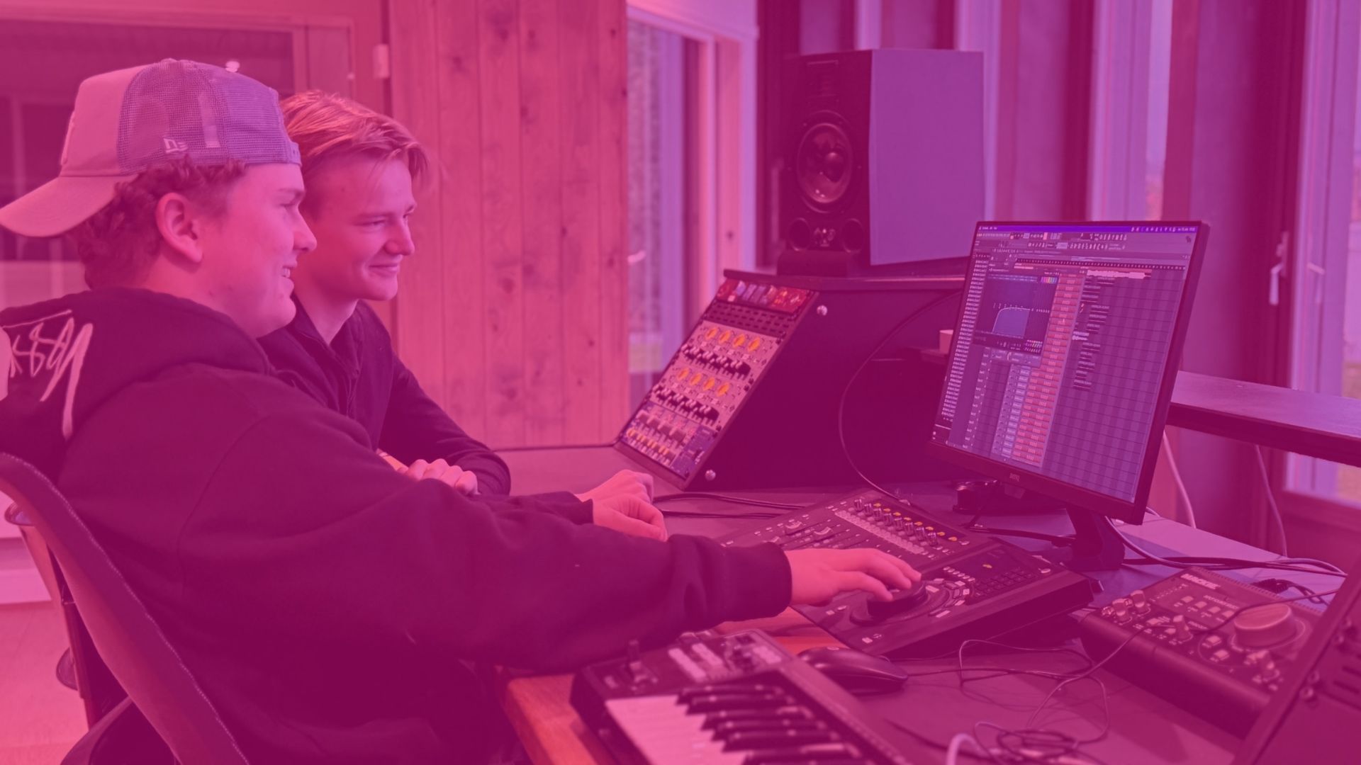 To glade gutter som programmerer musikk i studio på Musikkfolkehøgskolen Viken