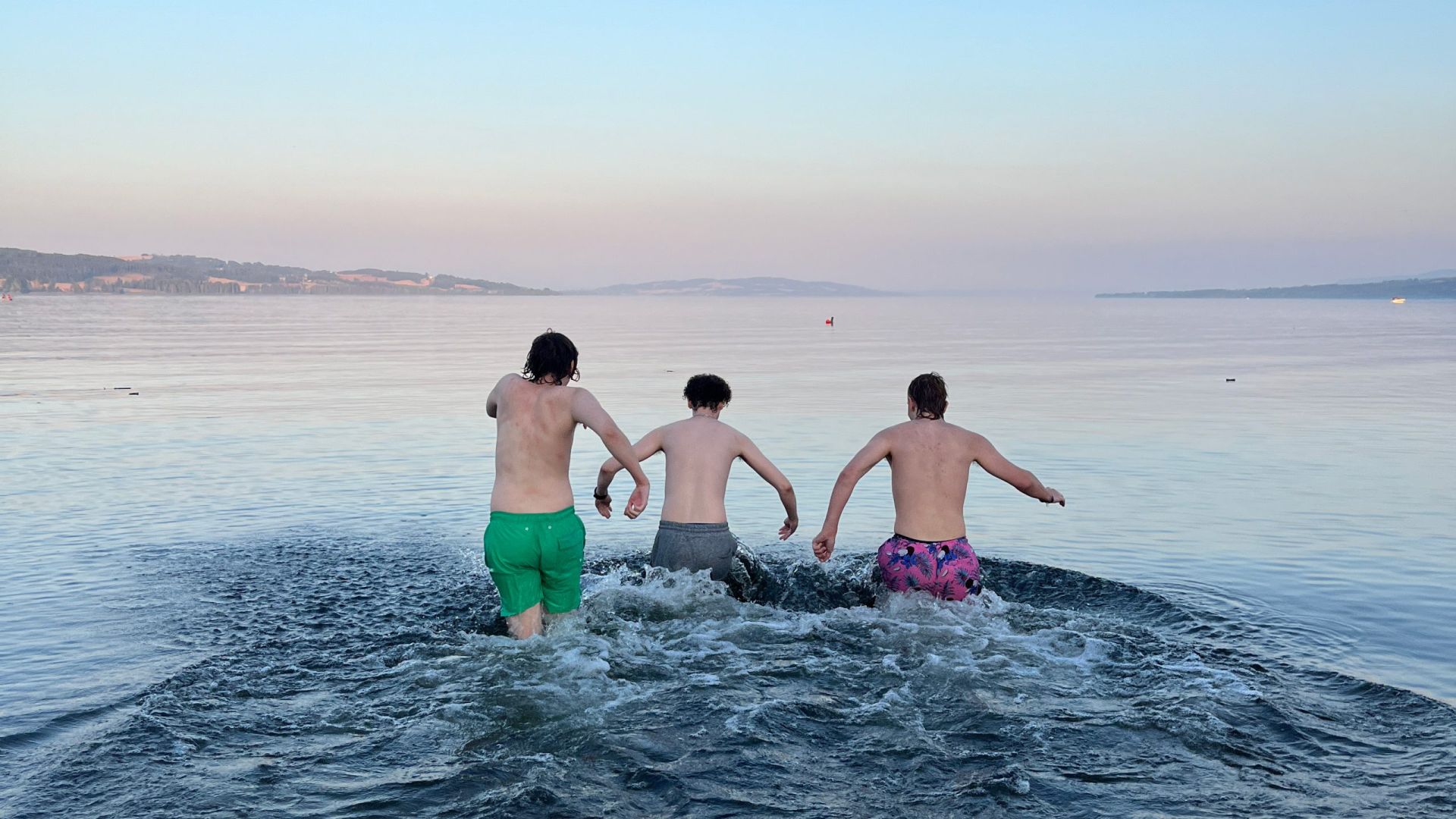 Tre gutter i badebukse løper ut i Mjøsa