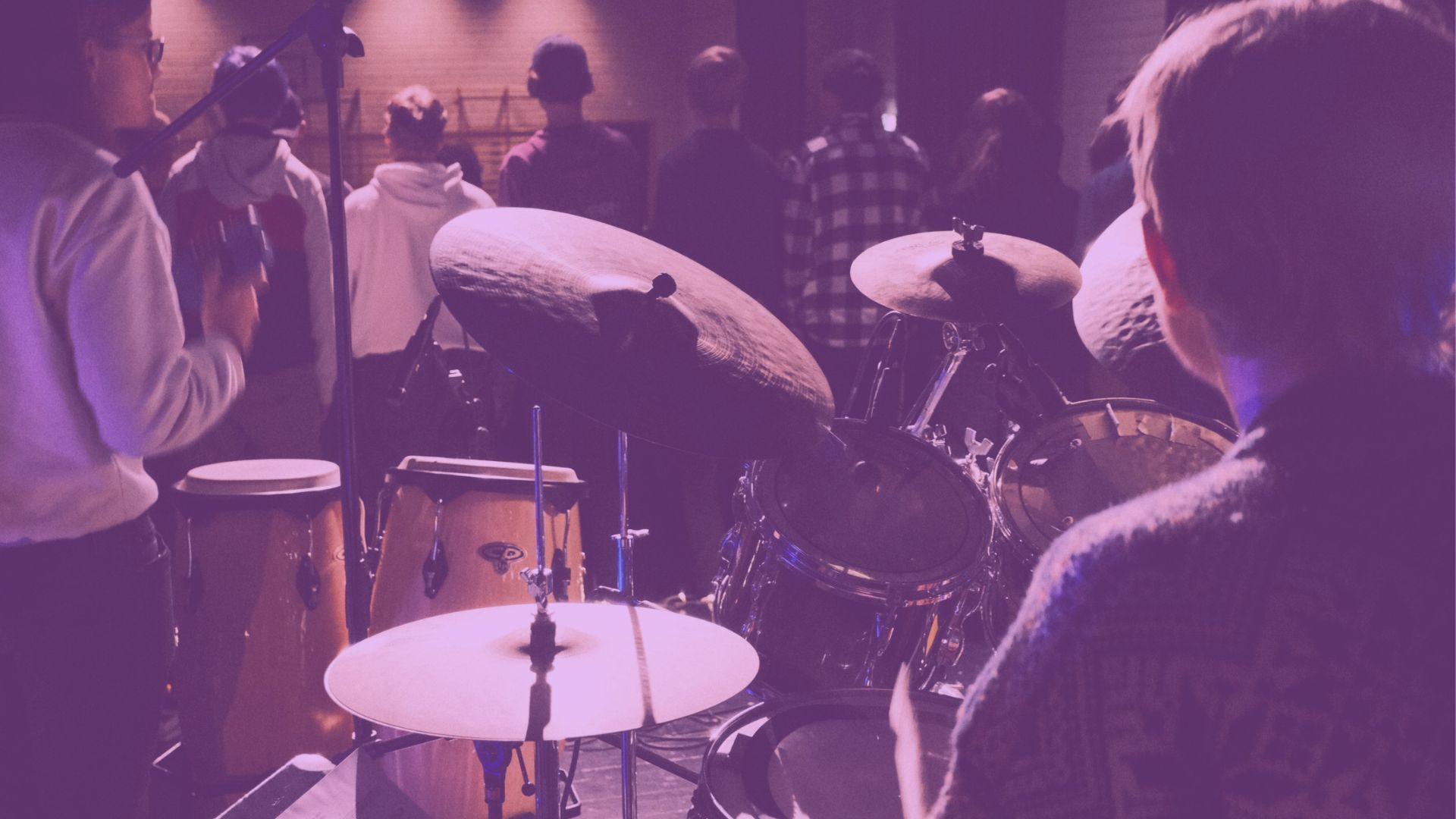 Trommeslager og trommer på scenen sett bakfra på Musikkfolkehøgskolen Viken