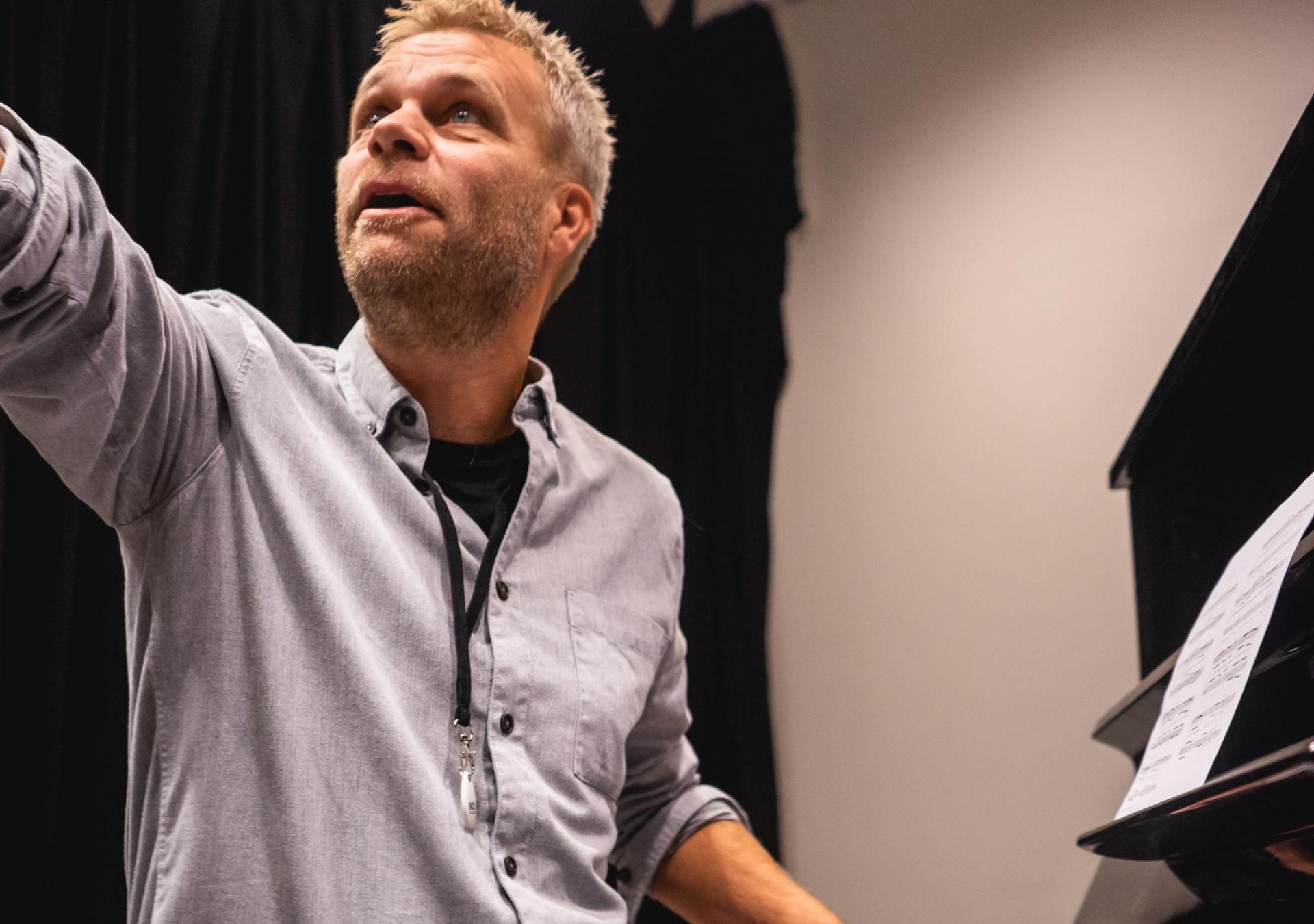Morten Reppesgård sitter ved pianoet og instruerer