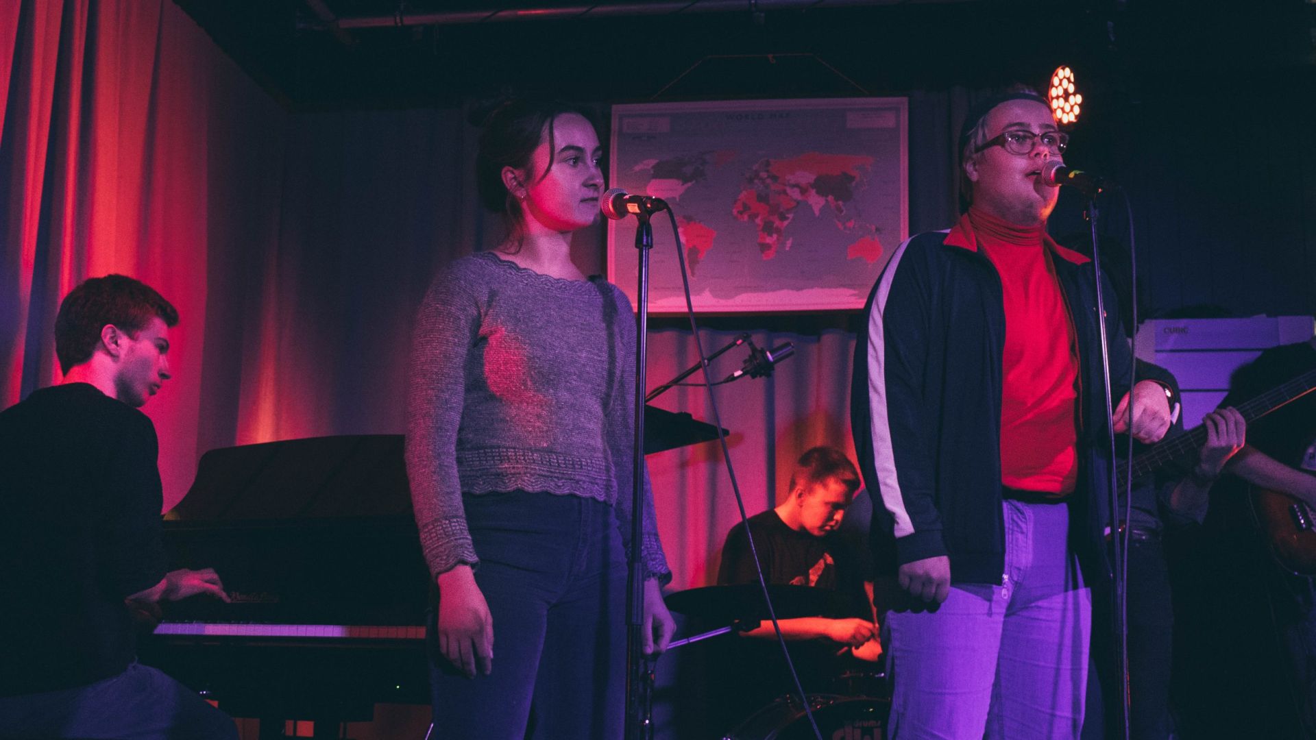 To vokalister og en pianist på scenen